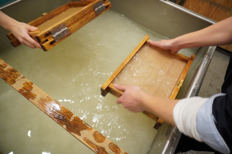 流濾工序的一部分。深吸混有原料的水，使纖維纏繞